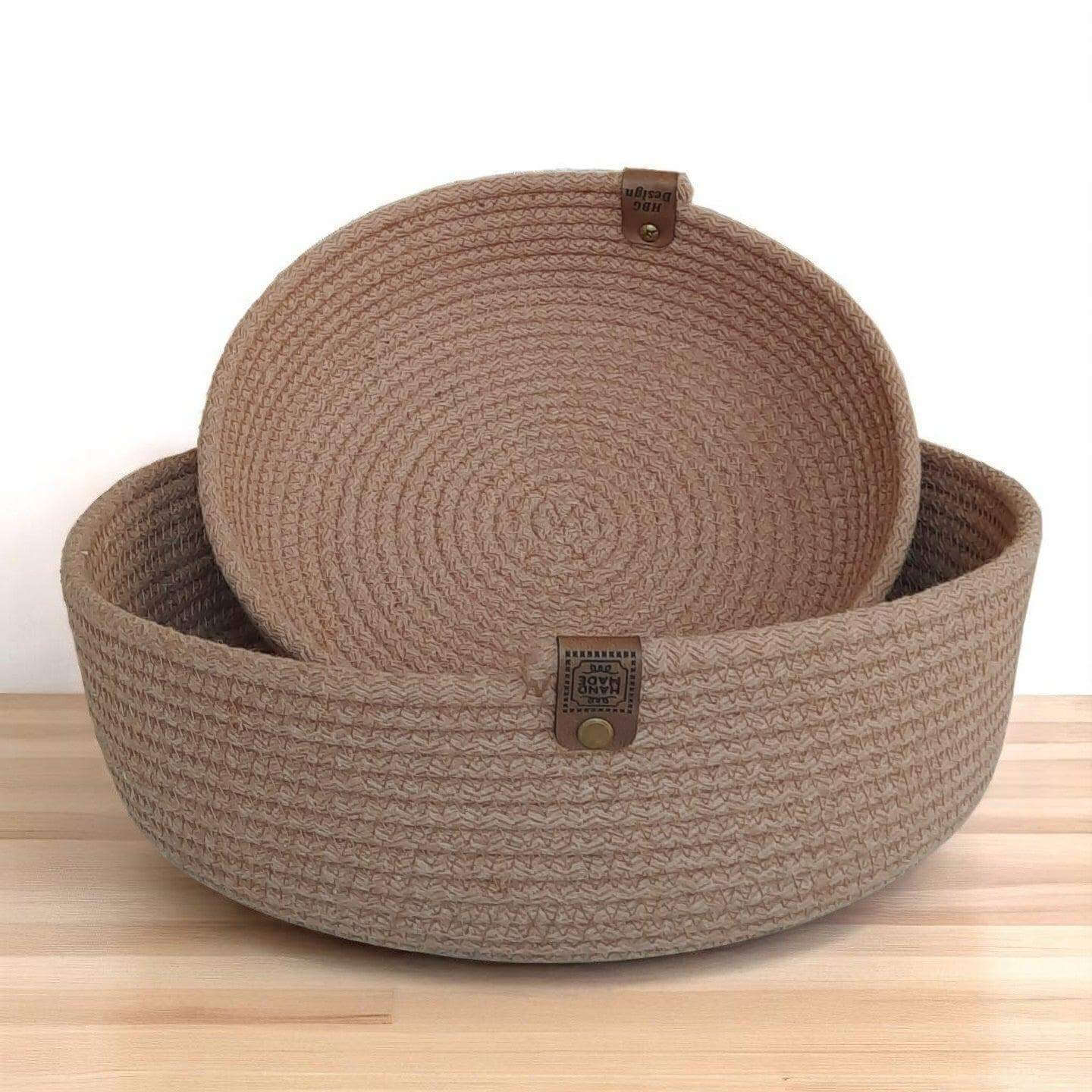 2 mandjes in kleur milky coffee gemaakt van gevlochten naaikoorden. Afmetingen: 23x6 en 29x9cm