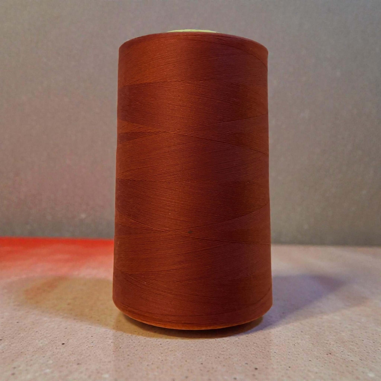 Polyester naaigaren Terracotta 120 (40/2) op kegel van 5000 meter, sterk en pluisarm naaigaren geschikt voor naaimachine en handnaaien.
