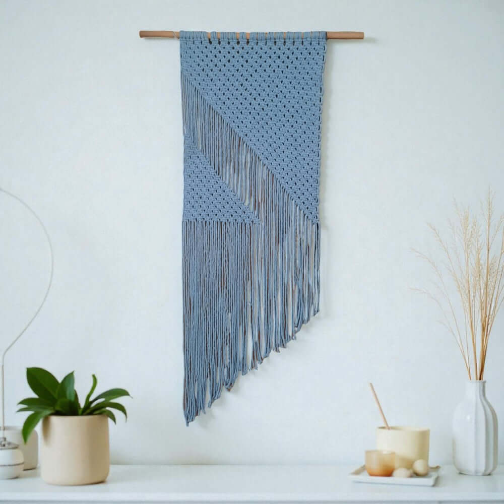 Maak zelf dit mooie moderne wandkleed met het Cafune Macrame pakket wandkleed. De kleur van het kleed is lichtblauw