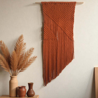 Maak zelf dit mooie moderne wandkleed met het Cafuné Macramé pakket wandkleed De kleur van het kleed is Terracotta. 