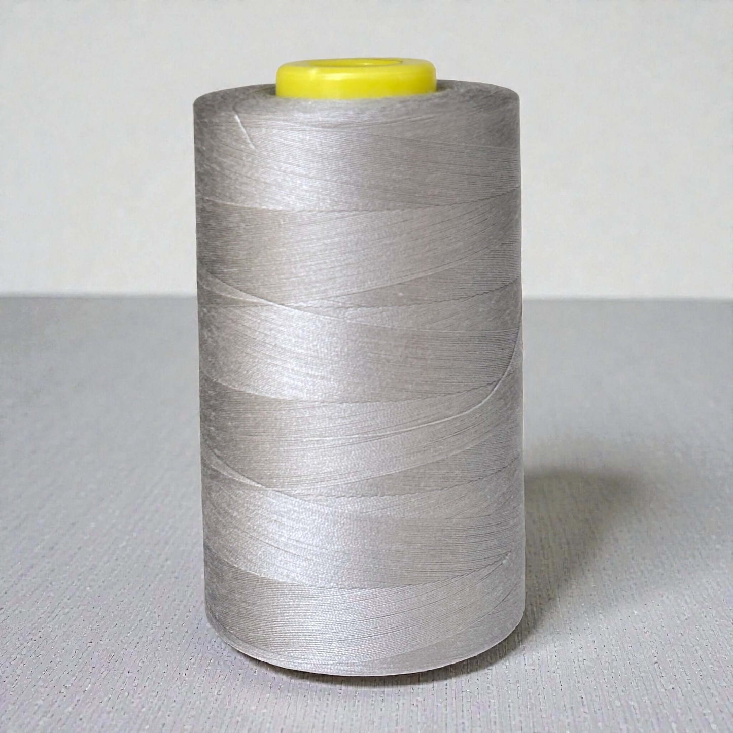 Polyester naaigaren Grijs 120 (40/2) op kegel van 5000 meter, sterk en pluisarm naaigaren geschikt voor naaimachine en handnaaien.